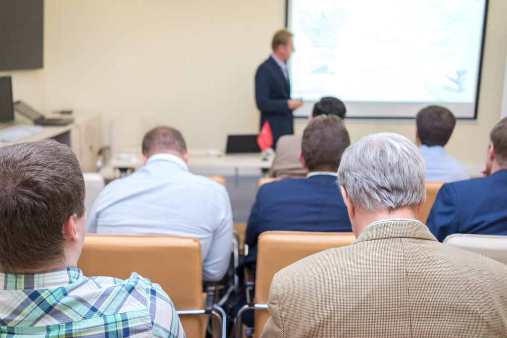 The audience listens to the acting in a conference hall.